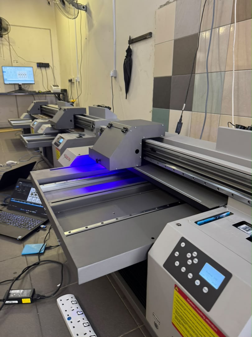 Row of UV printers curing prints at the ezLASER.my service workshop
